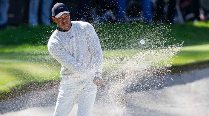 Tiger Woods hits from the sand on the 10th hole during the first round of the 2024 Genesis Invitational.